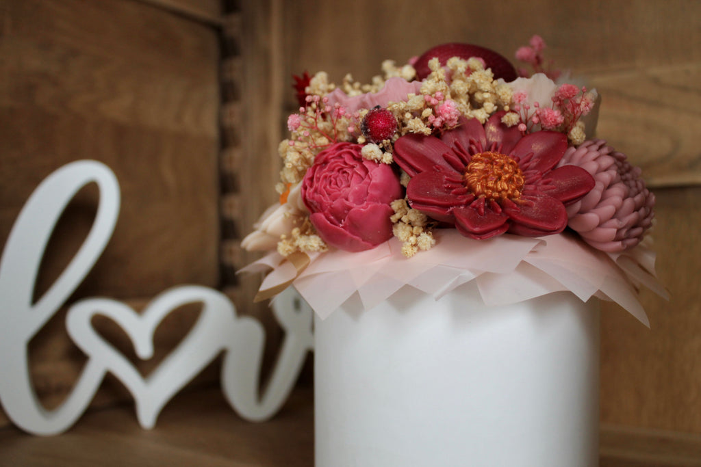 Zoom sur les fleurs en cire façonnées à la main, aux teintes rose, bordeaux et ivoire. Un bouquet trompe-l’œil raffiné qui allie esthétique florale et bougies parfumées artisanales.