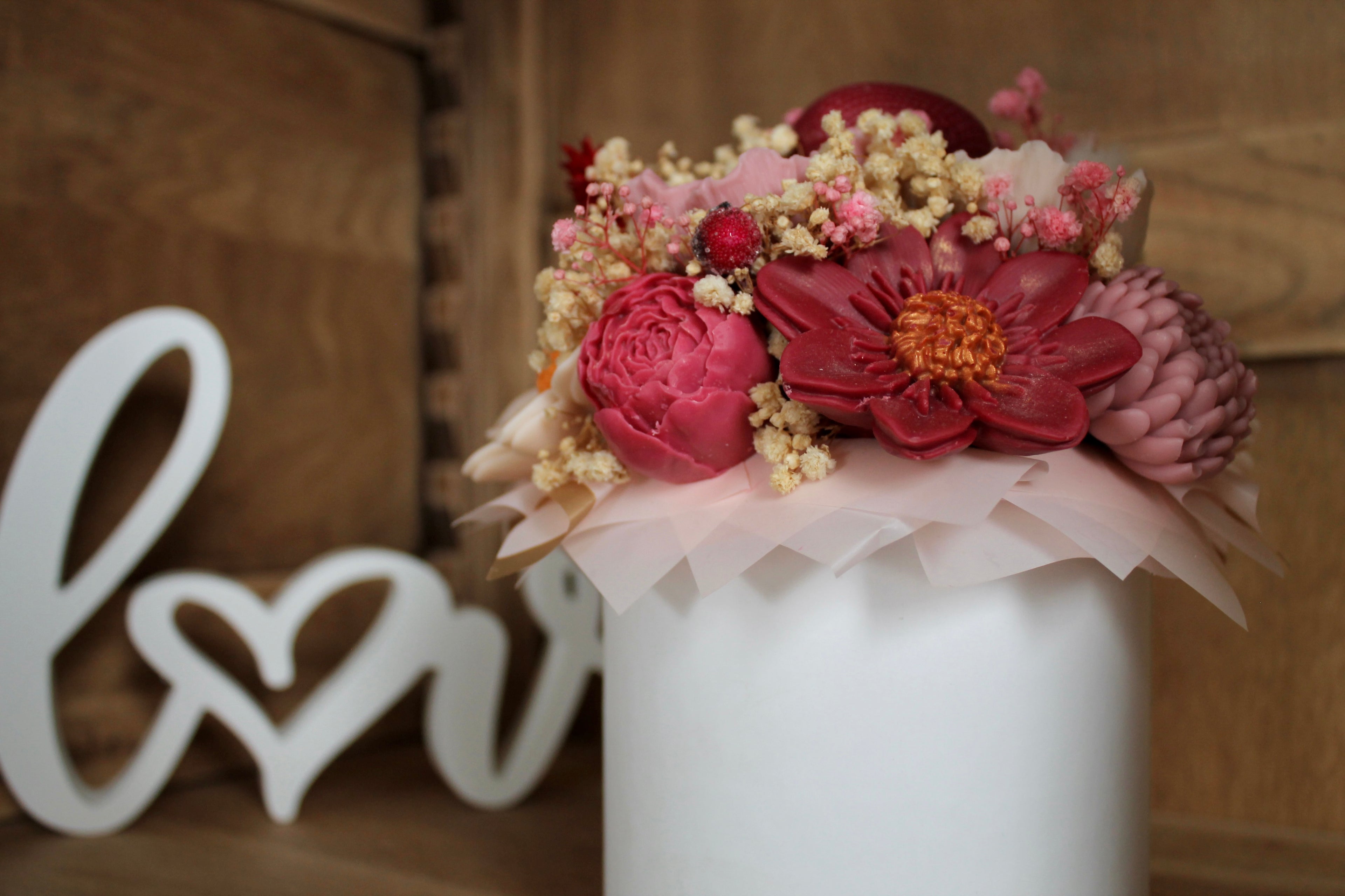 Zoom sur les fleurs en cire façonnées à la main, aux teintes rose, bordeaux et ivoire. Un bouquet trompe-l’œil raffiné qui allie esthétique florale et bougies parfumées artisanales.
