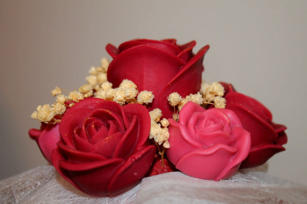 Gros plan sur un bouquet de roses en cire artisanales rouges et roses, fleurs décoratives faites main
