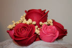 Gros plan sur un bouquet de roses en cire artisanales rouges et roses, fleurs décoratives faites main